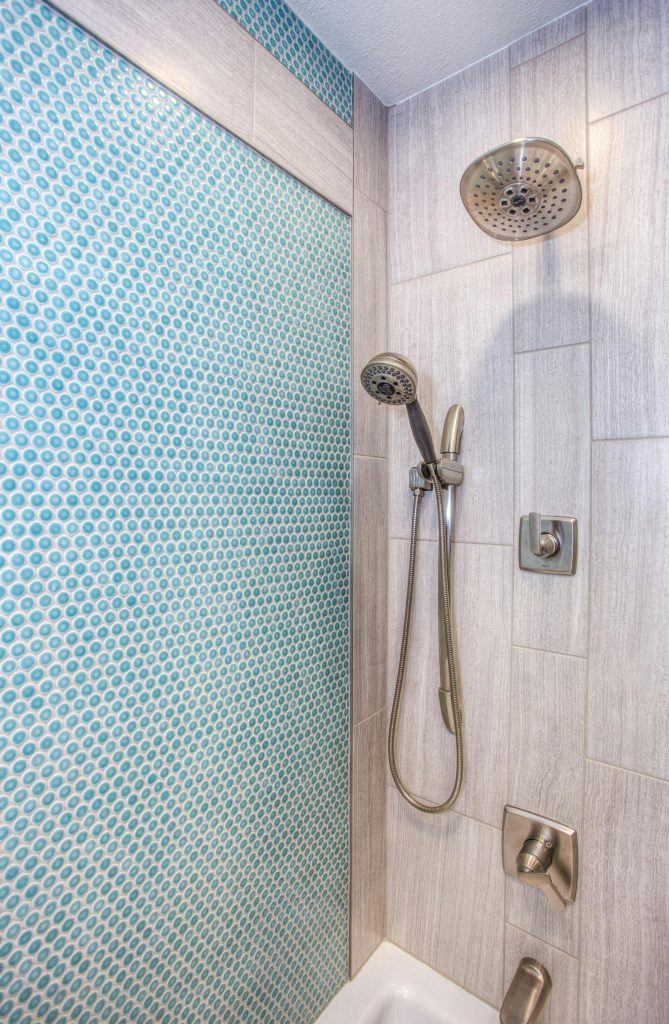 pexels-photo-1909656-1909656 Elegant shower design featuring blue mosaic tiles and stainless steel fixtures.